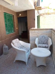 a patio with two chairs and a table and a coffee table at 1B studio 2beds air conditioned basement114 green beach in El Alamein