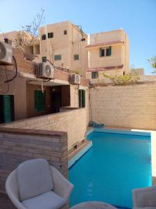 a swimming pool with a chair next to a building at 1B studio 2beds air conditioned basement114 green beach in El Alamein
