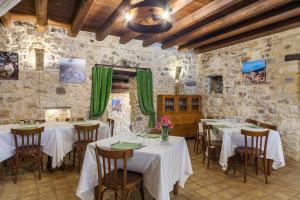 Masseria Fortificata Lo Zafferaneto في Buccheri: مطعم بطاولات وكراسي بجدار حجري