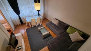ein Wohnzimmer mit einem Sofa und einem Tisch in der Unterkunft Slavija Square Apartments in Belgrad