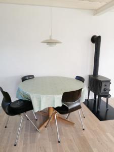 a dining room with a table and chairs and a stove at Big house in the countryside near UNESCO city in Christiansfeld