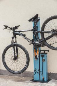 a bike on a bike stand next to a wall at Cadria Nature & Bike Hotel in Lenzumo di Concei