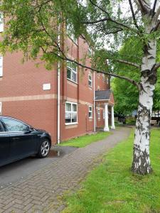 a black car parked in front of a brick building at Comfortable 2 Bed Apartment 2nd Floor Contractors Families Close To City Centre Occasional Bed Available in Coventry