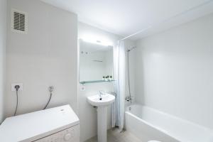 a white bathroom with a sink and a shower at Apartamentos Marblau in Tamariu +100 photos