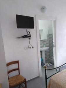 Pokój z telewizorem na ścianie i krzesłem w obiekcie B&B Villa Angela w mieście San Salvo
