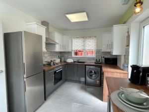 a kitchen with a stainless steel refrigerator and a dishwasher at Spacious House, Ideal for Contractors, Leisure or Corporate Stays in Derby