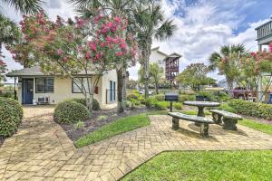 a park with two picnic tables and a tree with pink flowers at Panama City Condo w/ Balcony & Pool, Walk to Beach in Panama City Beach