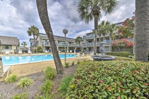 a resort with a swimming pool and palm trees at Panama City Condo w/ Balcony & Pool, Walk to Beach in Panama City Beach