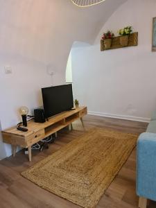 a living room with a tv on a wooden table at White Fish Mojacar in Mojácar