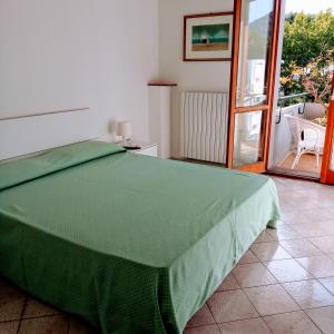 una camera con letto verde e balcone di Il Platano a Piano di Sorrento