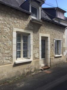 a stone house with two windows and a door at Le coin des Halles dans le vignoble de Bourgueil in Bourgueil
