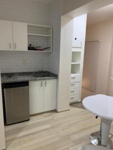 a kitchen with white cabinets and a white table at Monoambiente Plaza Belgrano in San Miguel de Tucumán