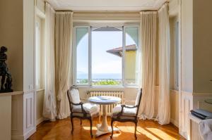 una sala da pranzo con tavolo, sedie e una grande finestra di ALTIDO Splendid Villa with Orange Trees and Stunning View a Santa Margherita Ligure