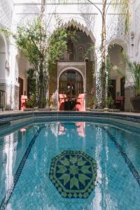 a large swimming pool in a building with trees at Riad & Spa Esprit Du Maroc in Marrakesh