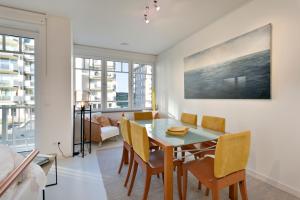 uma sala de jantar com mesa e cadeiras em Modern appartement met doorkijk op de duinen em Cadzand