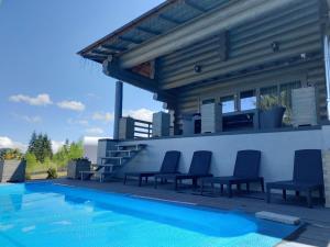 a swimming pool with chairs next to a house at "Шале Олень" in Yablunytsya