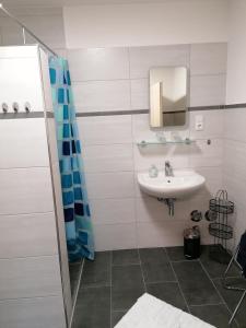 uma casa de banho branca com um lavatório e um espelho em Landgasthof Fischer em Lichtenfels