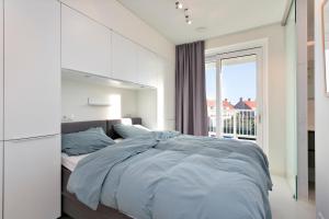 Un dormitorio con una cama grande y una ventana en Modern appartement met doorkijk op de duinen, en Cadzand