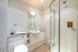 a bathroom with a shower and a toilet and a sink at Beachcombers Apartments in Newquay
