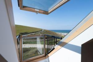 a room with a balcony with a view of the ocean at Beachcombers Apartments in Newquay