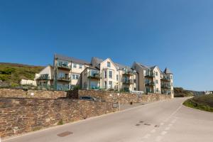 a row of houses on a wall next to a road at Beachcombers Apartments in Newquay