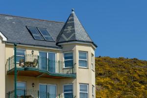 a large yellow building with a grey roof at Beachcombers Apartments in Newquay