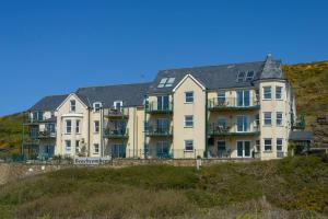 a large apartment building on a hill next to the ocean at Beachcombers Apartments in Newquay