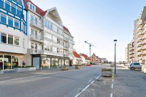 an empty street in a city with buildings at Modern appartement met doorkijk op de duinen in Cadzand