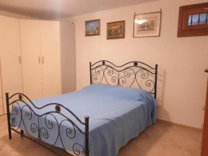 Schlafzimmer mit einem Bett mit blauer Tagesdecke in der Unterkunft Villa Arisa with pool in Selva di Fasano
