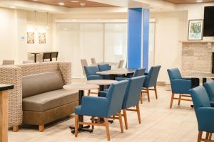- une salle d'attente avec des tables et des chaises bleues dans l'établissement Holiday Inn Express Winona, an IHG Hotel, à Winona