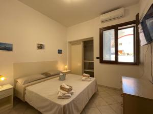 una camera da letto con un letto e asciugamani di Villino Dei Ginepri a Baia Verde
