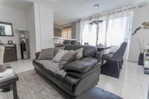 a living room with a leather couch and a table at Appartement à 700m gare centrale/plage in Pointe-Noire