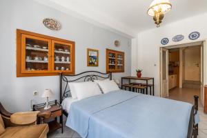 スコペロスにあるYiayia's guesthouseのベッドルーム1室(青い掛け布団付きのベッド1台付)