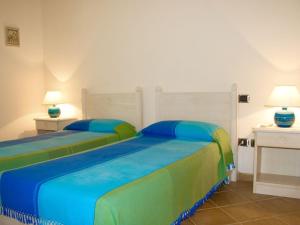 a bedroom with two beds with blue and green sheets at Villa Luna Smeralda ad Alghero villa con piscina ad uso esclusivo per 8 persone in Alghero +86 photos