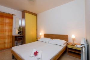 Apartment in Bol with Seaview, Balcony, Air condition, WIFI (156-9) في بول: غرفة نوم بسرير ابيض وعليه ورد