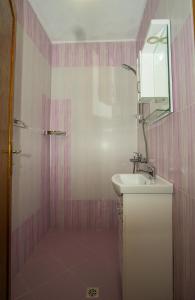 a pink bathroom with a sink and a mirror at Guest apartments STELA in Tsarevo