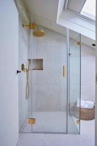 una ducha con puerta de cristal en un baño en Helguera Palacio Boutique & Antique, en Torrelavega