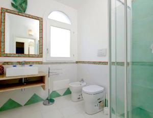 a bathroom with a toilet and a sink and a mirror at Magnificent Villa: SUPER PANORAMIC in Costa Rei