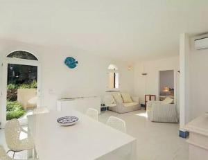 a white living room with a white table and chairs at Magnificent Villa: SUPER PANORAMIC in Costa Rei +18 photos