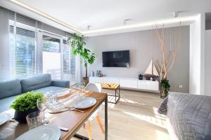 una sala de estar con una mesa y un sofá en Apartament AP10, en Mielno