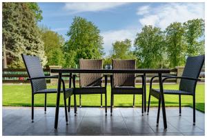 a table and four chairs sitting on a patio at Kenese Regatta Apartman in Balatonkenese