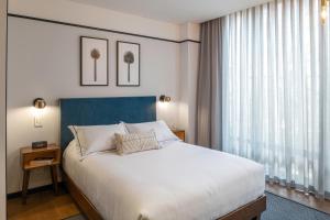a bedroom with a large bed and a large window at HAB Hotel Bogotá in Bogotá