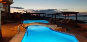 a resort swimming pool with a view of the ocean at Irides in Souvala