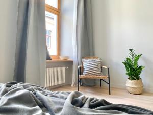 een slaapkamer met een bed, een stoel en een raam bij Stylish New Apartment in Riga Old Town - City Centre, Self Check-in, Walkable to Major Attractions in Rīga
