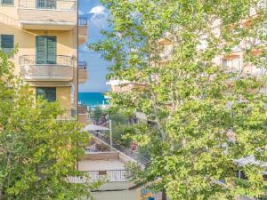a view of a building from between trees at Hotel City in Misano Adriatico