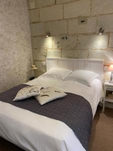 a large white bed with two pillows on it at Logis Hôtel Auberge De L'ecole in Pontlevoy