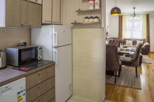 a kitchen with a refrigerator and a dining room at Apartman Orion in Žabljak