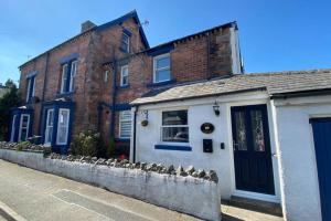 una casa con puertas azules en una calle en Poet's Corner - flat close to centre of Keswick en Keswick