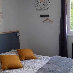 ein Schlafzimmer mit einem Bett mit gelben Kissen und einem Fenster in der Unterkunft Relais Saint Vincent in Thonville