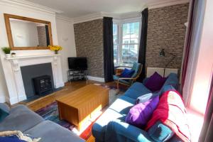 a living room with a blue couch and a fireplace at Poet's Corner - flat close to centre of Keswick in Keswick